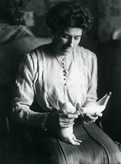 De vrouw van een verzorger voedt een pasgeboren ijsbeerwelp met de fles, London Zoo, c.1914 door Frederick William Bond